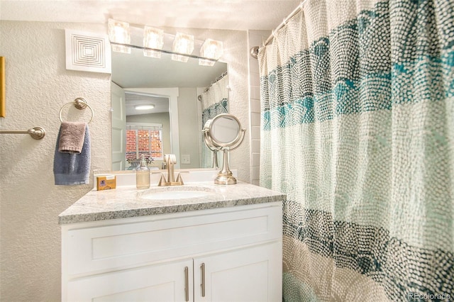 bathroom with walk in shower and vanity