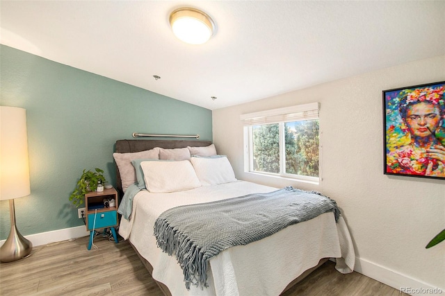 bedroom featuring hardwood / wood-style flooring and vaulted ceiling