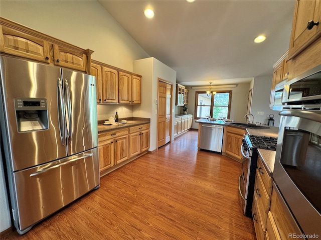 100 River Run Dr, Buena Vista, CO 81211 - kitchen featuring stainless steel appliances, wood finished floors, a peninsula, a sink, and brown cabinetry