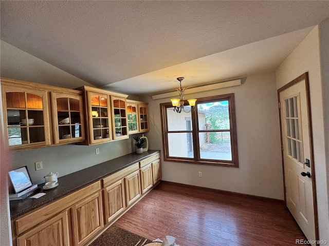 100 River Run Dr, Buena Vista, CO 81211 - kitchen featuring dark countertops, wood-type flooring, a chandelier, glass insert cabinets, and hanging light fixtures