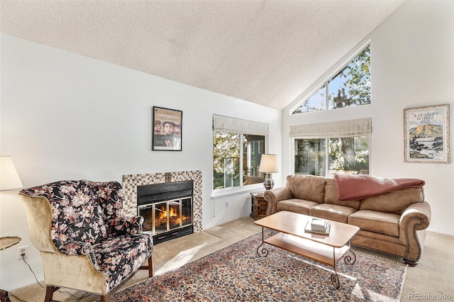 carpeted living room featuring high vaulted ceiling, a tiled fireplace, and a textured ceiling