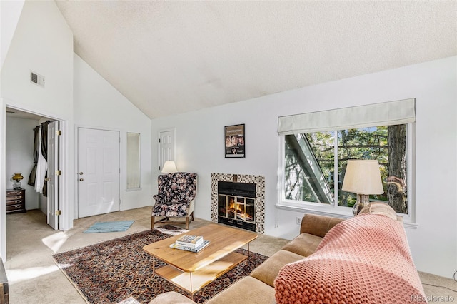 carpeted living room featuring a fireplace, high vaulted ceiling, and a textured ceiling