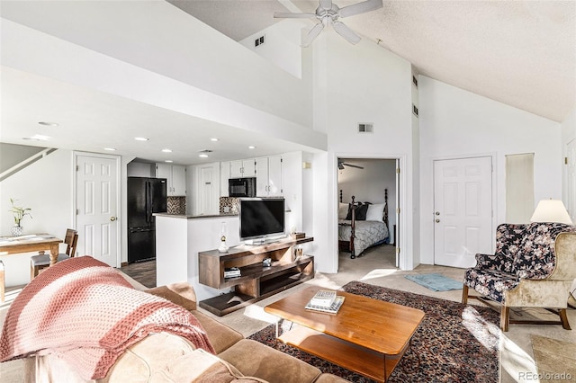 carpeted living room with high vaulted ceiling, ceiling fan, and a textured ceiling