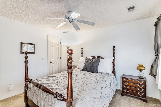 bedroom with ceiling fan, a textured ceiling, and carpet flooring