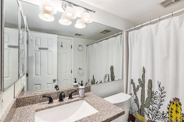 bathroom featuring walk in shower, vanity, and toilet