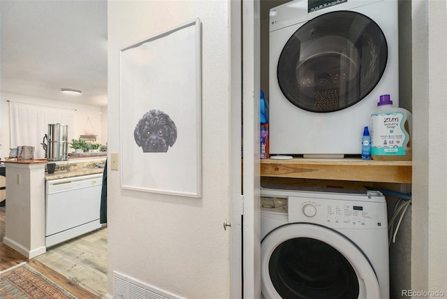 laundry room featuring wood finished floors and stacked washer and clothes dryer