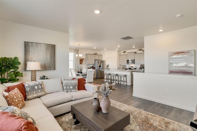 living room with a notable chandelier and hardwood / wood-style flooring