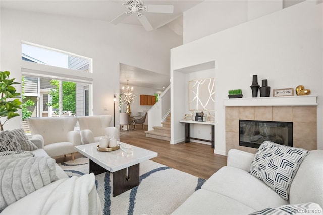 10681 Cherrybrook Cir, Highlands Ranch, CO 80126 - living room featuring wood finished floors, stairway, high vaulted ceiling, a tiled fireplace, and a ceiling fan