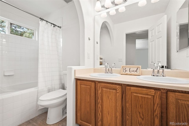 10681 Cherrybrook Cir, Highlands Ranch, CO 80126 - full bath with double vanity, toilet, tiled shower / bath combo, and wood finished floors