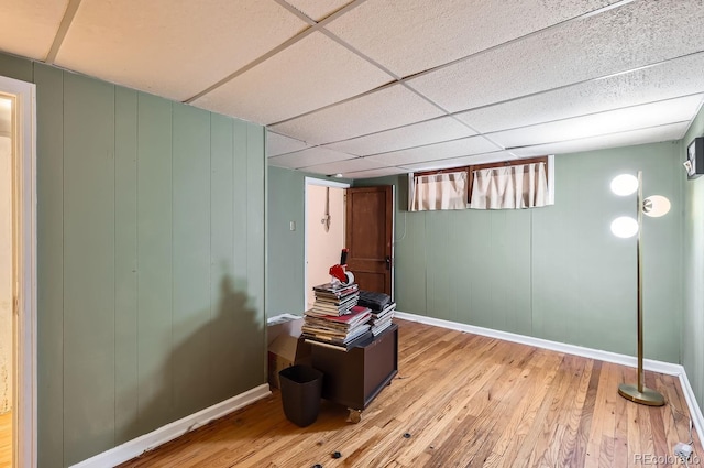 basement with light wood-type flooring and a drop ceiling