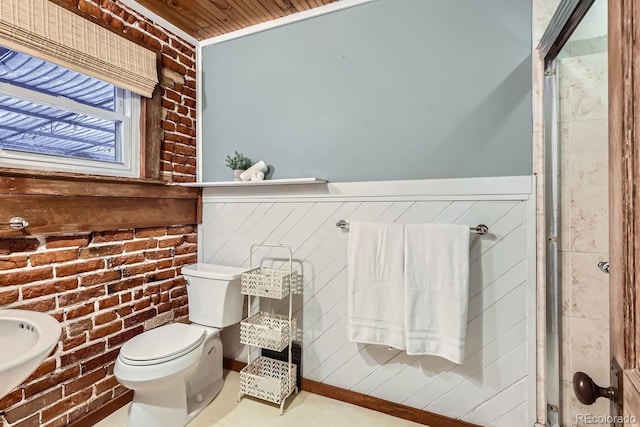 bathroom with toilet and brick wall