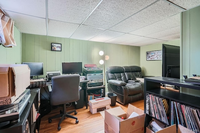 office with hardwood / wood-style flooring, a drop ceiling, and wooden walls