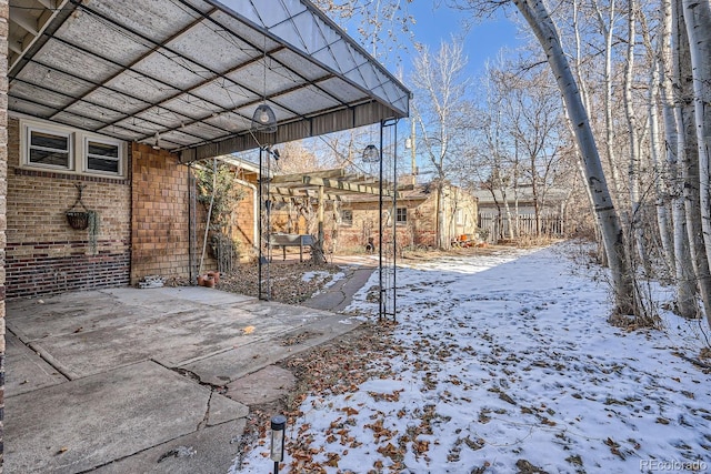 yard covered in snow featuring a carport