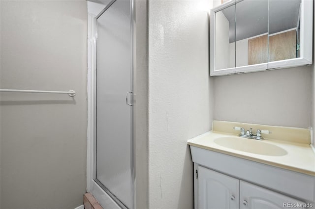 bathroom featuring vanity and a shower with door