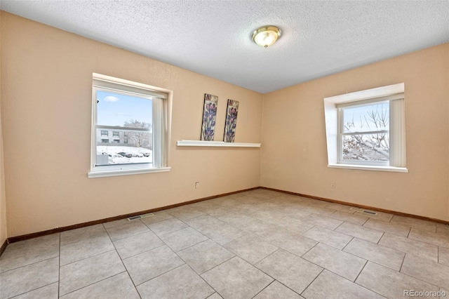 unfurnished room with a healthy amount of sunlight and a textured ceiling