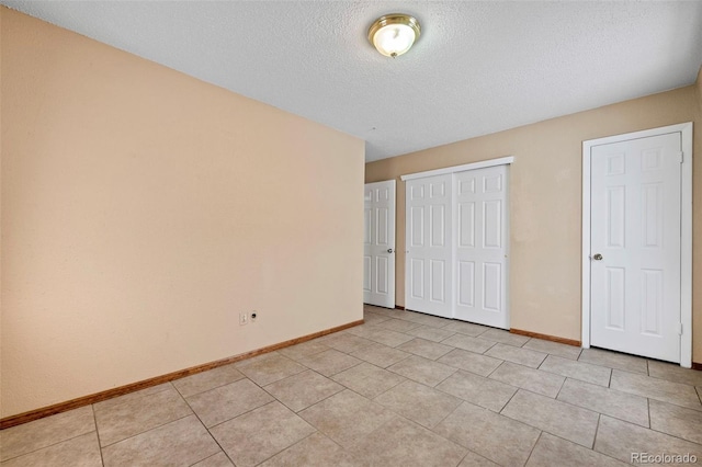 unfurnished bedroom with light tile patterned floors and a textured ceiling