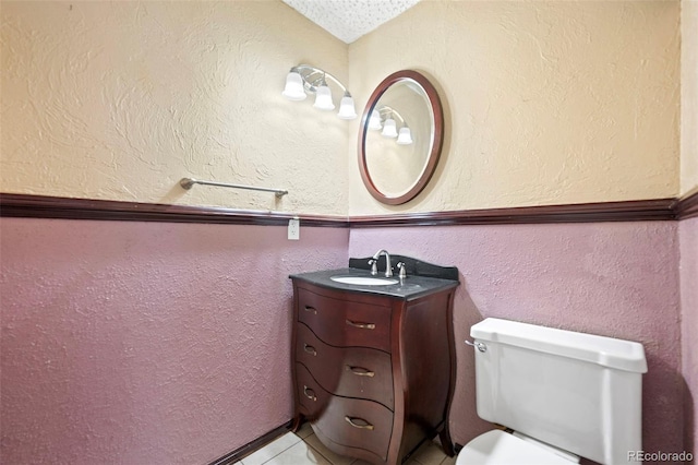 bathroom featuring tile patterned flooring, vanity, vaulted ceiling, and toilet