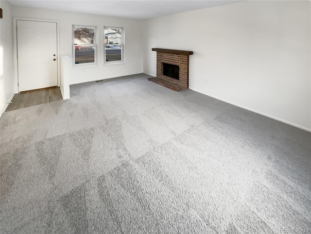 unfurnished living room with a fireplace and dark colored carpet