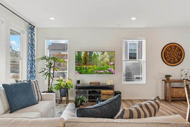 living room with recessed lighting, baseboards, and wood finished floors