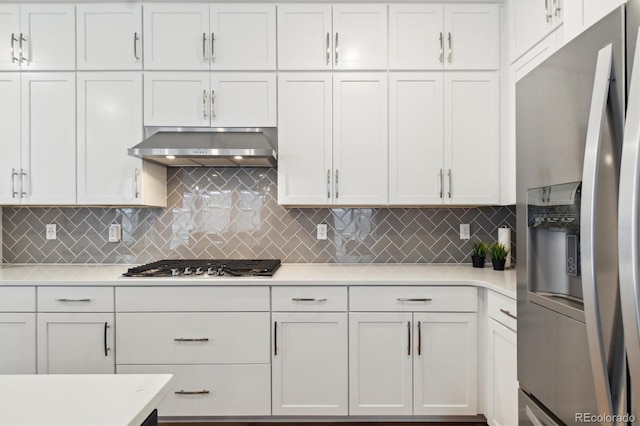 kitchen with appliances with stainless steel finishes, light countertops, white cabinetry, and exhaust hood