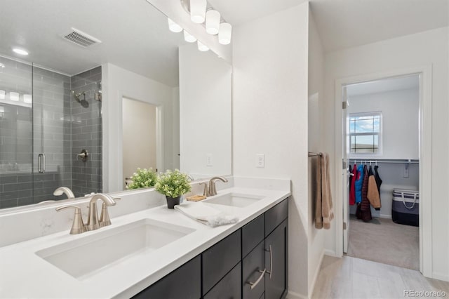 full bathroom featuring double vanity, a sink, visible vents, and a shower stall