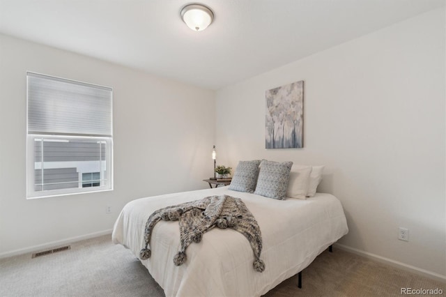 carpeted bedroom featuring visible vents and baseboards