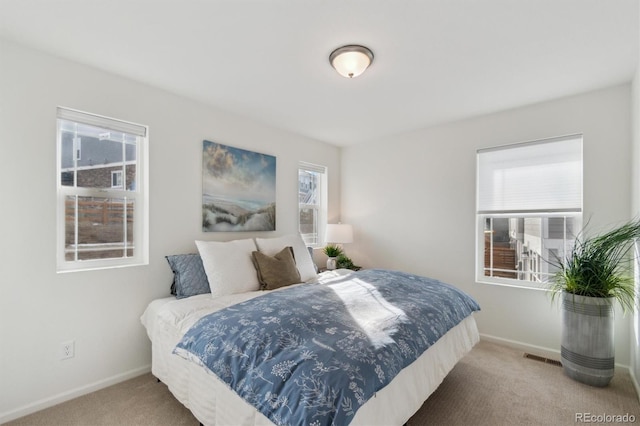 carpeted bedroom with visible vents and baseboards