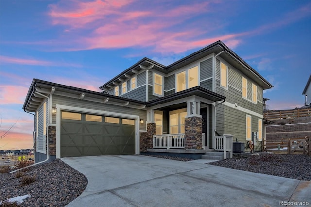 view of front of home featuring a porch, an attached garage, fence, driveway, and stone siding