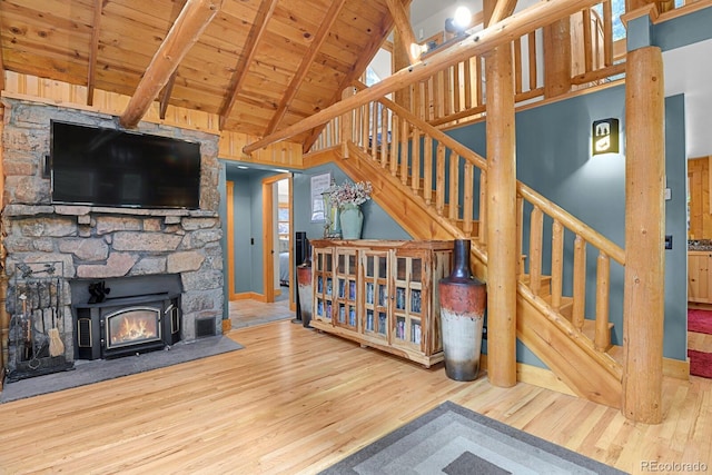 8905 Carol Ln, Conifer, CO 80433 - unfurnished living room with wood finished floors, wooden ceiling with exposed beams, high vaulted ceiling, stairway, and a fireplace