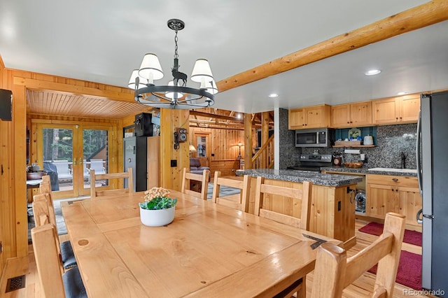 8905 Carol Ln, Conifer, CO 80433 - dining room with a chandelier, beamed ceiling, wooden walls, stairs, and french doors