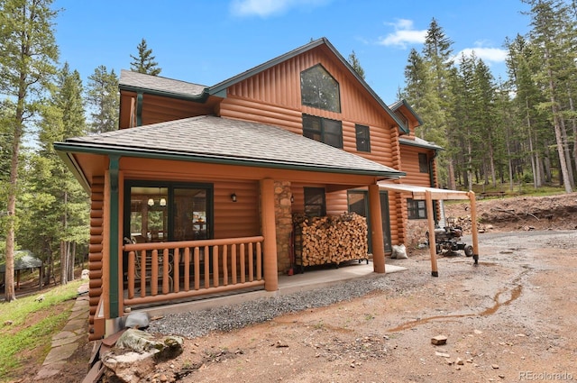 8905 Carol Ln, Conifer, CO 80433 - cabin with covered porch, board and batten siding, and roof with shingles