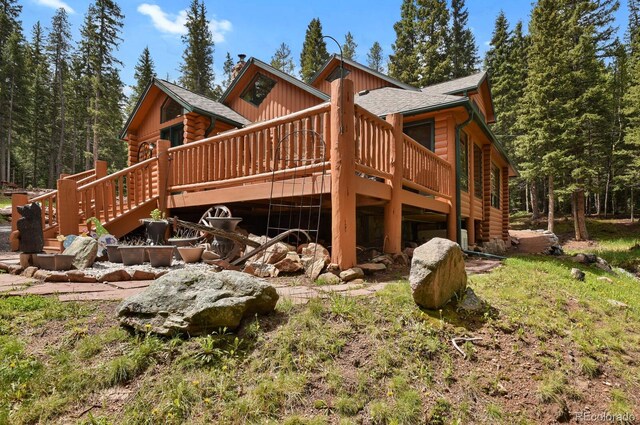8905 Carol Ln, Conifer, CO 80433 - rear view of property with log siding, a wooden deck, and roof with shingles