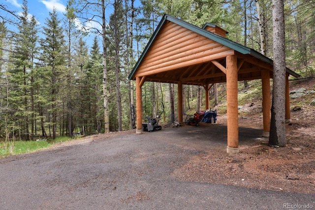 8905 Carol Ln, Conifer, CO 80433 - view of parking / parking lot featuring a carport, asphalt driveway, and a wooded view