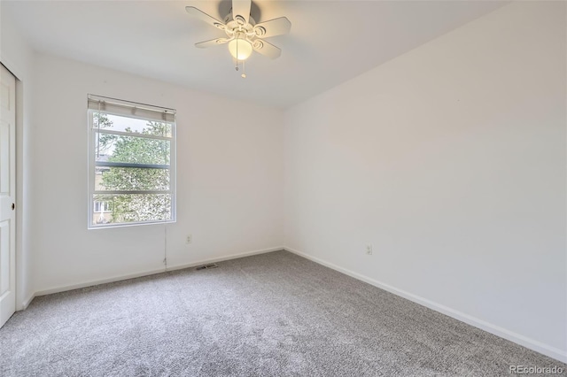 spare room featuring baseboards, carpet flooring, a ceiling fan, and visible vents