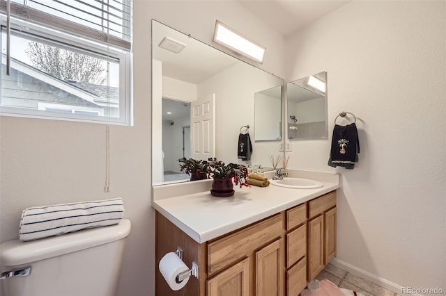 bathroom featuring vanity, tile patterned floors, baseboards, and toilet