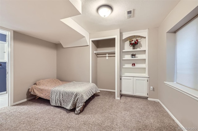bedroom with baseboards, light colored carpet, and a closet