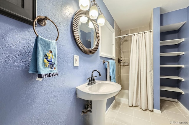 full bathroom with tile patterned floors, a textured wall, and a shower with shower curtain