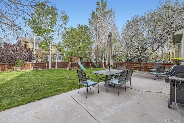 view of patio / terrace featuring outdoor dining area, a fenced backyard, a playground, and a grill