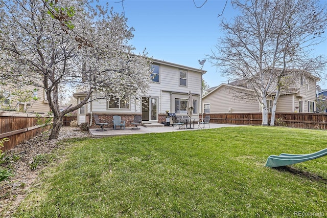 rear view of house with a lawn, entry steps, a fenced backyard, and a patio area