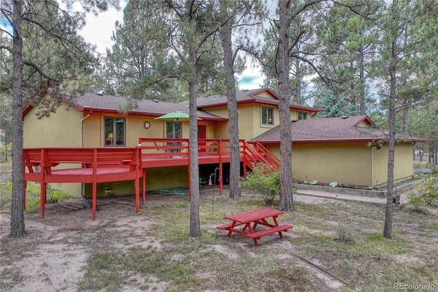 8510 Wilderness Dr, Colorado Springs, CO 80908 - back of house with roof with shingles, stucco siding, stairs, and a wooden deck