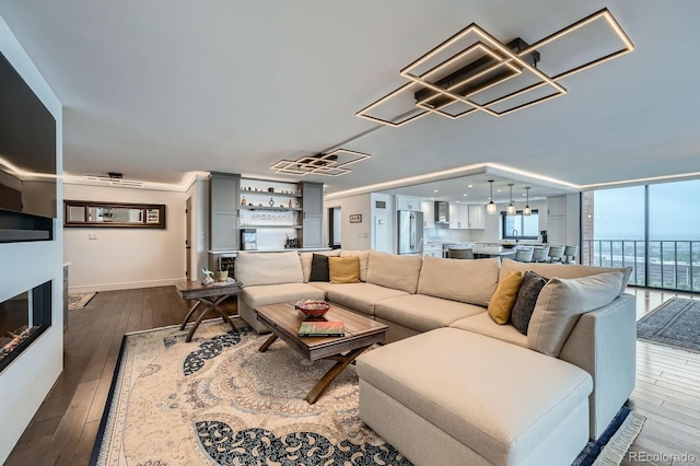 1551 Larimer St Unit 1901, Denver, CO 80202 - living area featuring a chandelier, dark wood-type flooring, a glass covered fireplace, and bar area