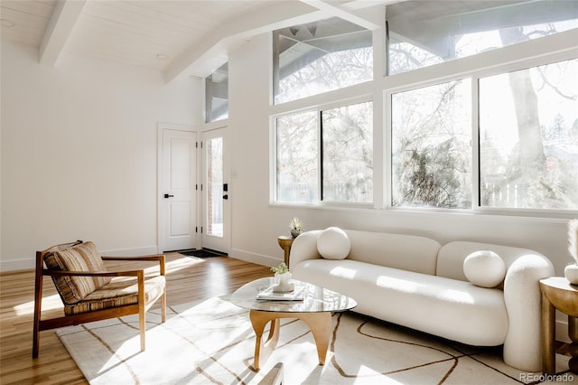 living room with vaulted ceiling with beams, hardwood / wood-style flooring, and wooden ceiling