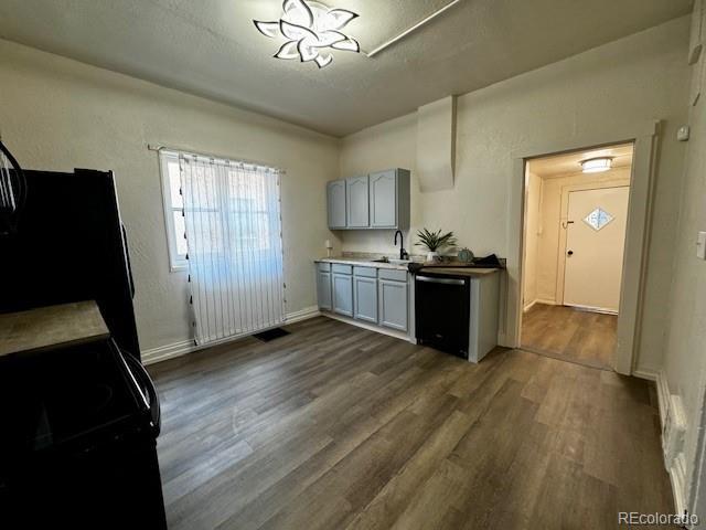 kitchen featuring black appliances, dark hardwood / wood-style floors, and sink