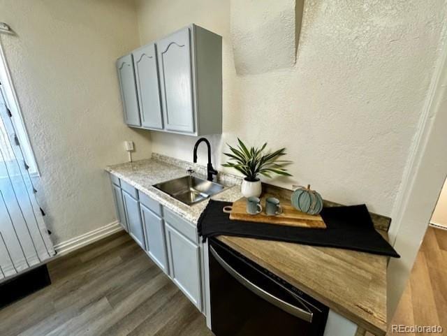 kitchen with gray cabinets, dishwasher, sink, and dark hardwood / wood-style floors