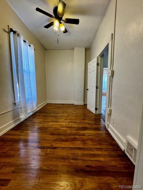 empty room featuring dark hardwood / wood-style flooring and ceiling fan