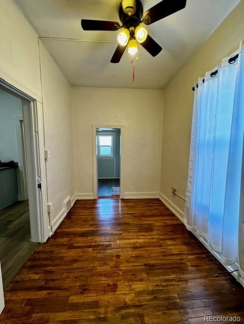 spare room with ceiling fan and dark wood-type flooring