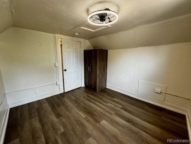 bonus room with a textured ceiling, dark hardwood / wood-style floors, and vaulted ceiling