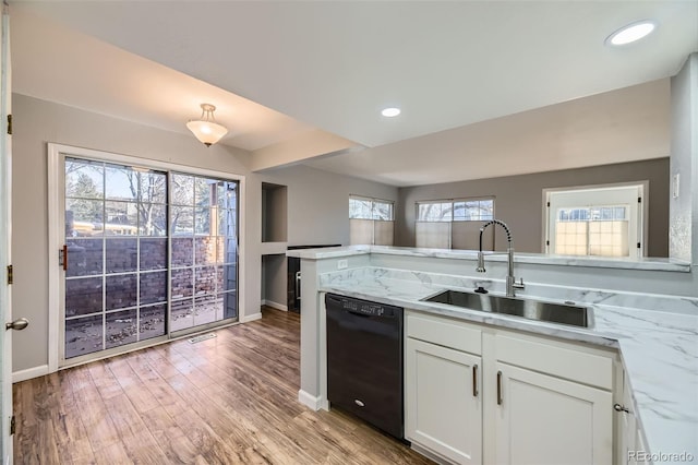 kitchen with white cabinetry, dishwasher, sink, light stone countertops, and light wood-type flooring