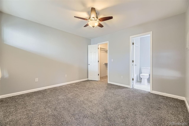 unfurnished bedroom with connected bathroom, a walk in closet, carpet, ceiling fan, and a closet