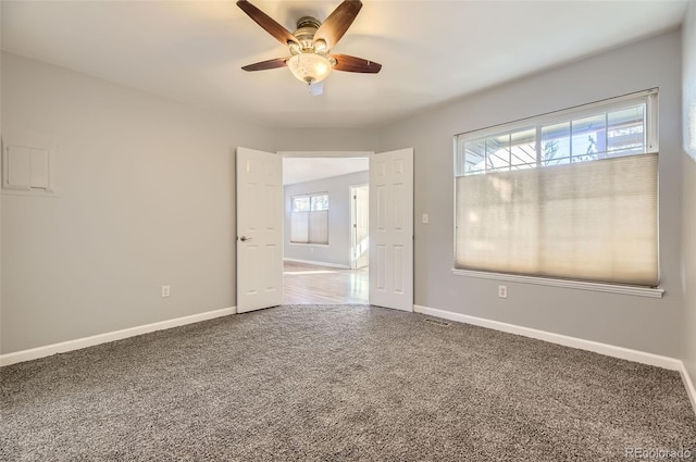 carpeted spare room featuring ceiling fan